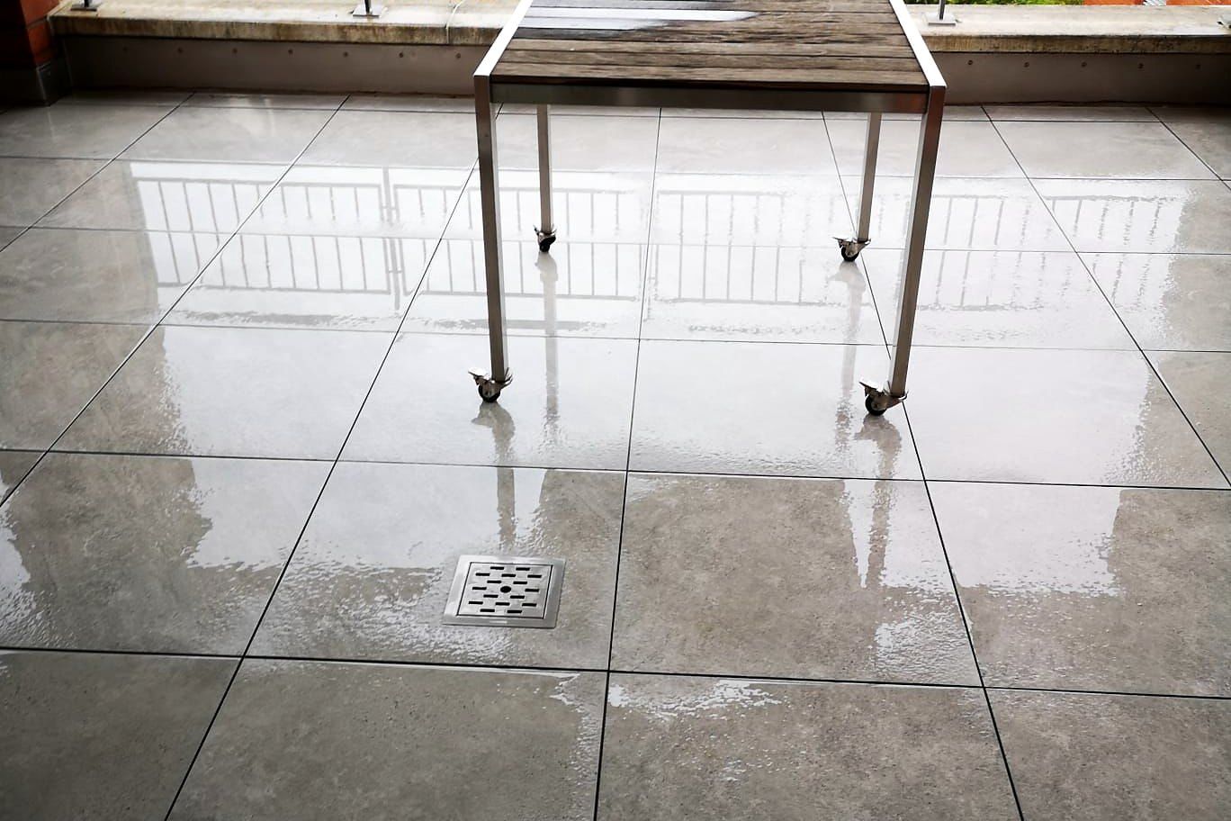Terrasse mit neuem Plattenboden und Geländer, nach Regen
