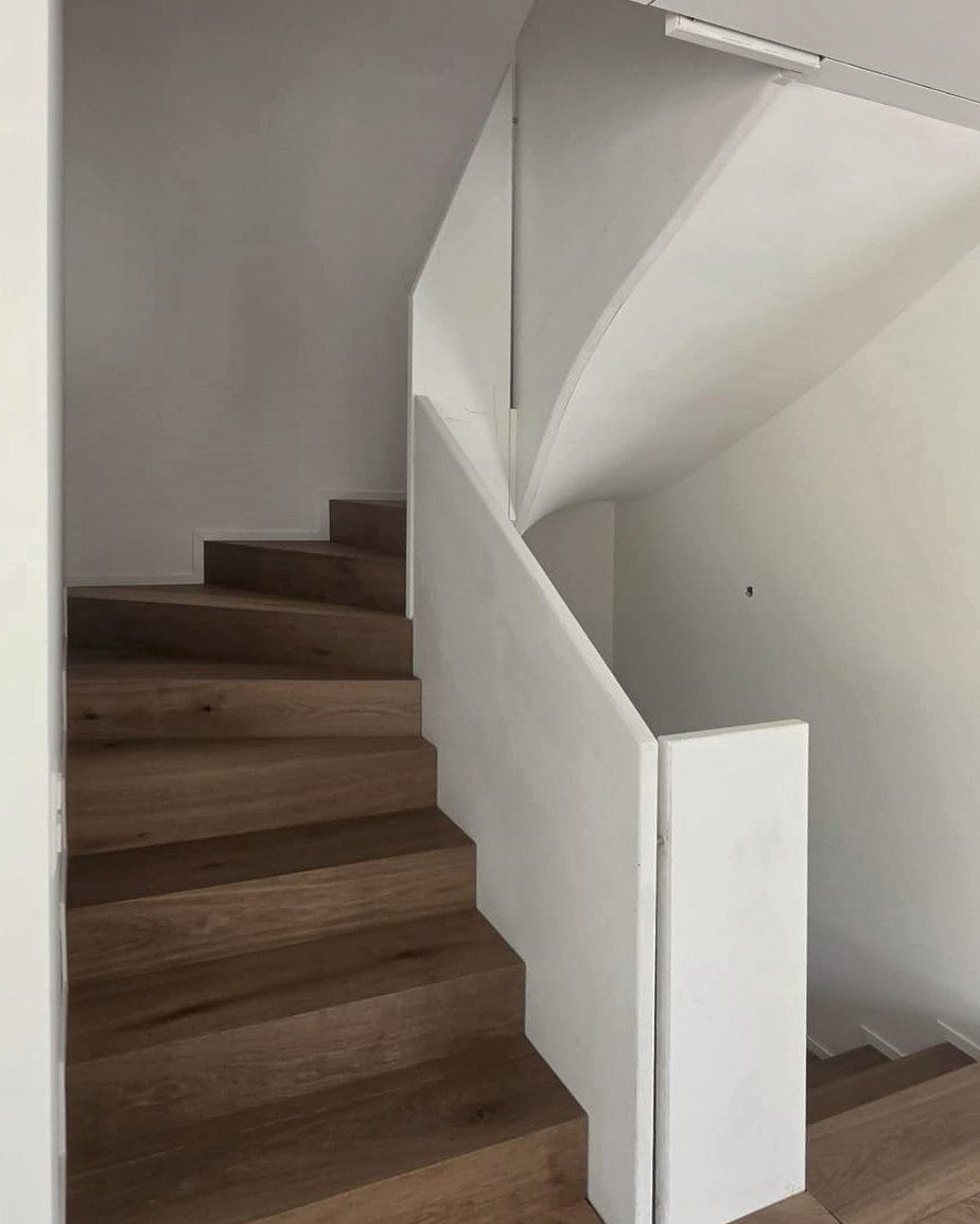 Gewendelte Treppe mit Eichenbelag und weisser Brüstung