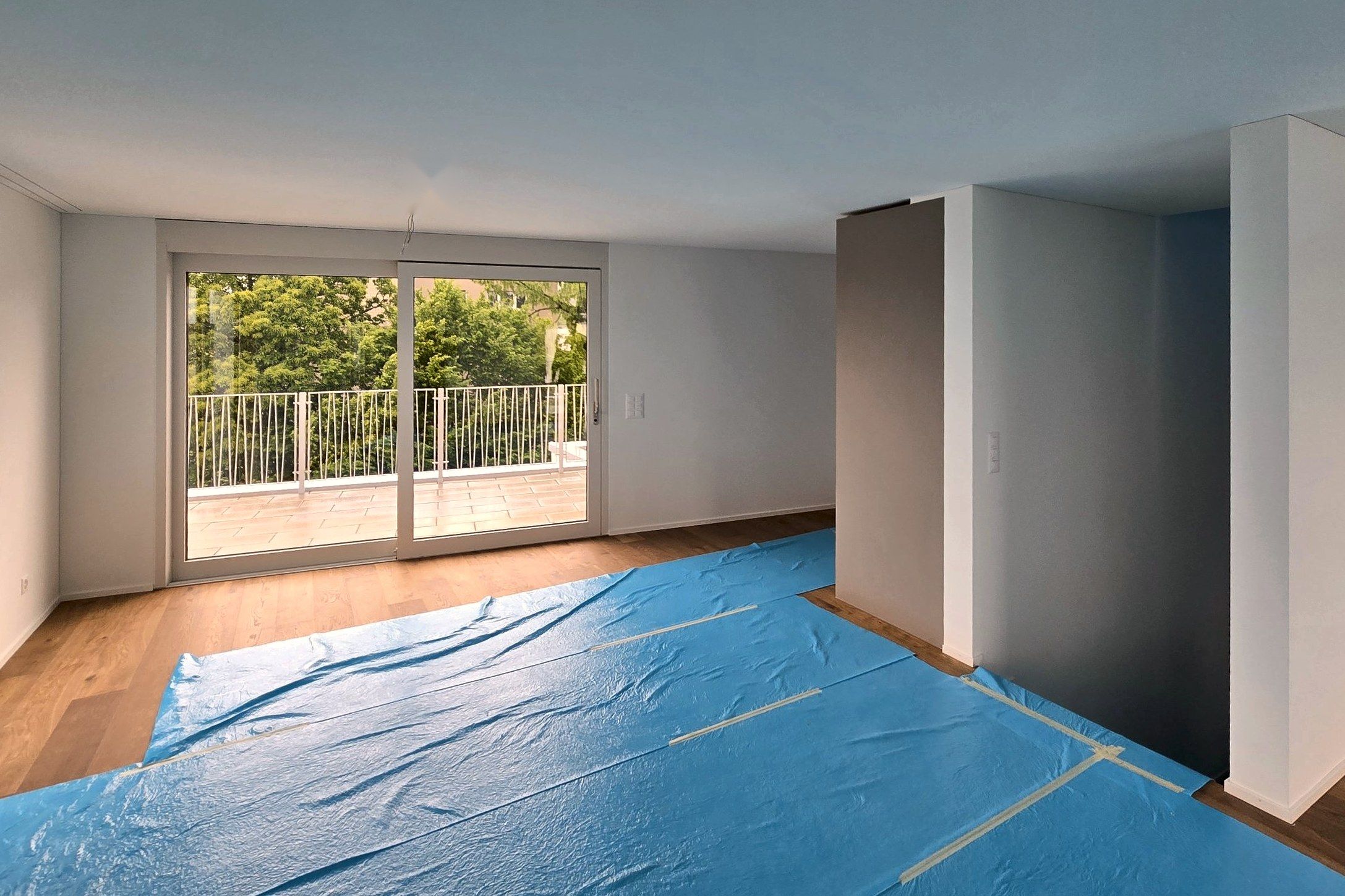 Wohnraum mit Schiebetür zur Terrasse, Boden mit Schutzfolie abgedeckt