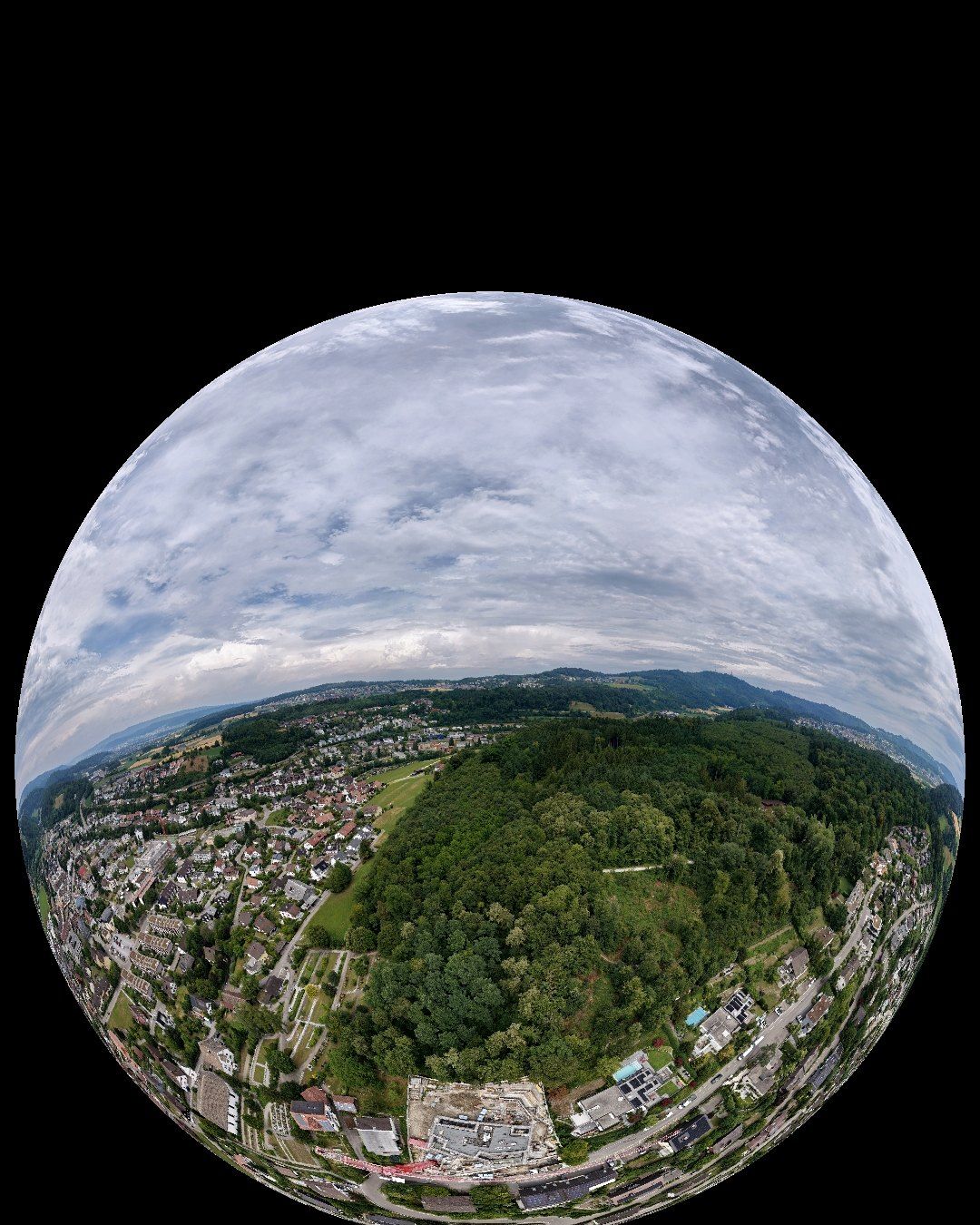 Drohnenbild als Kugelpanorama: Baustelle zwischen Wald, Quartier und Hügeln