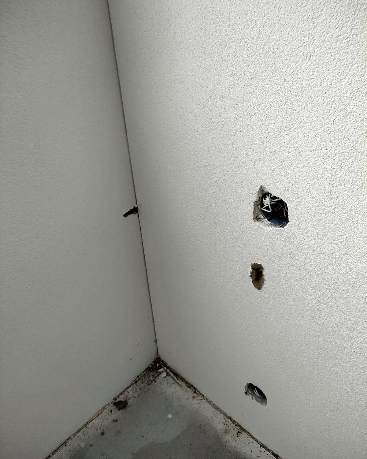 Ausbrüche nahe der Raumecke, Bohrloch sichtbar