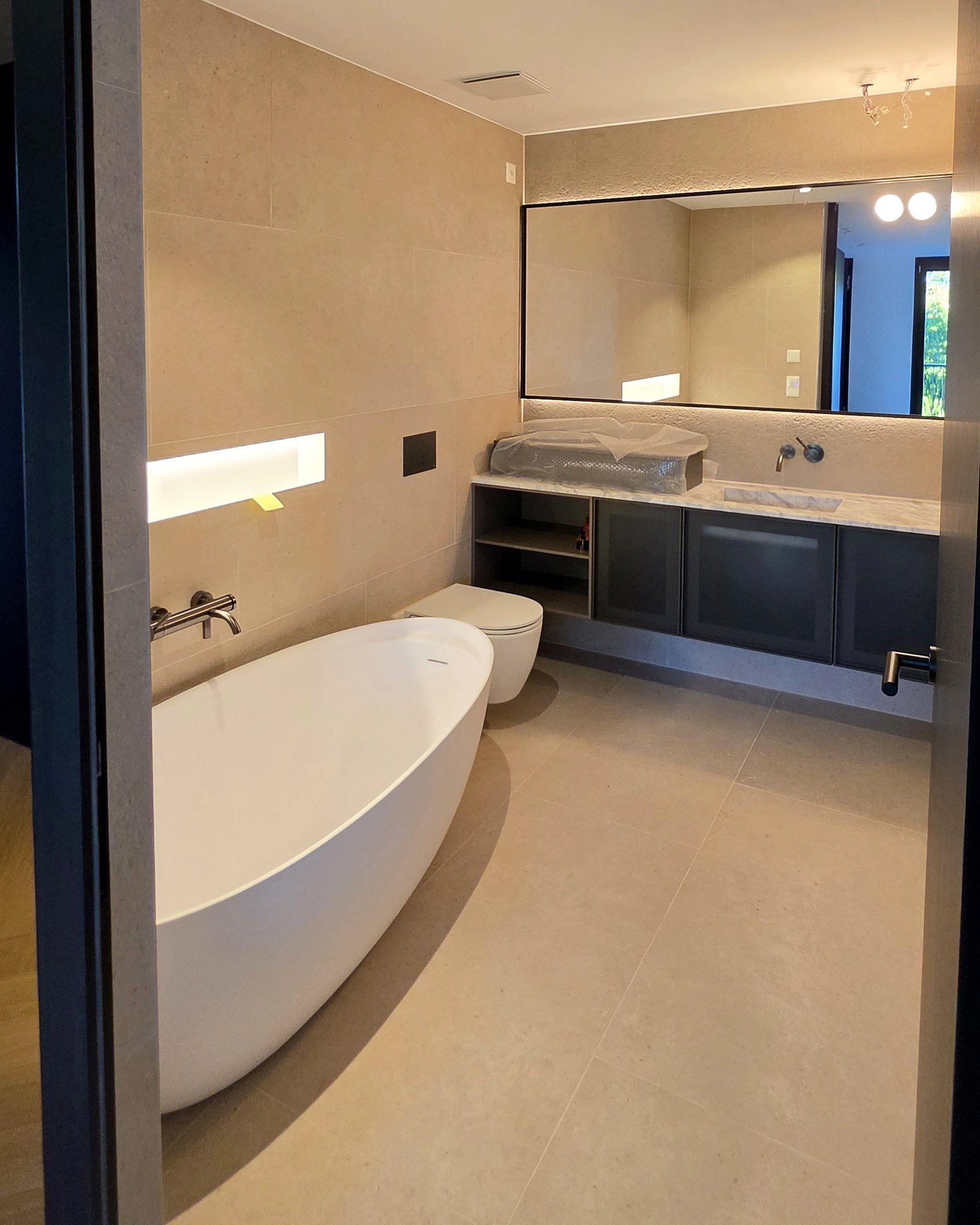 Badezimmer mit freistehender Badewanne und Doppellavabo
