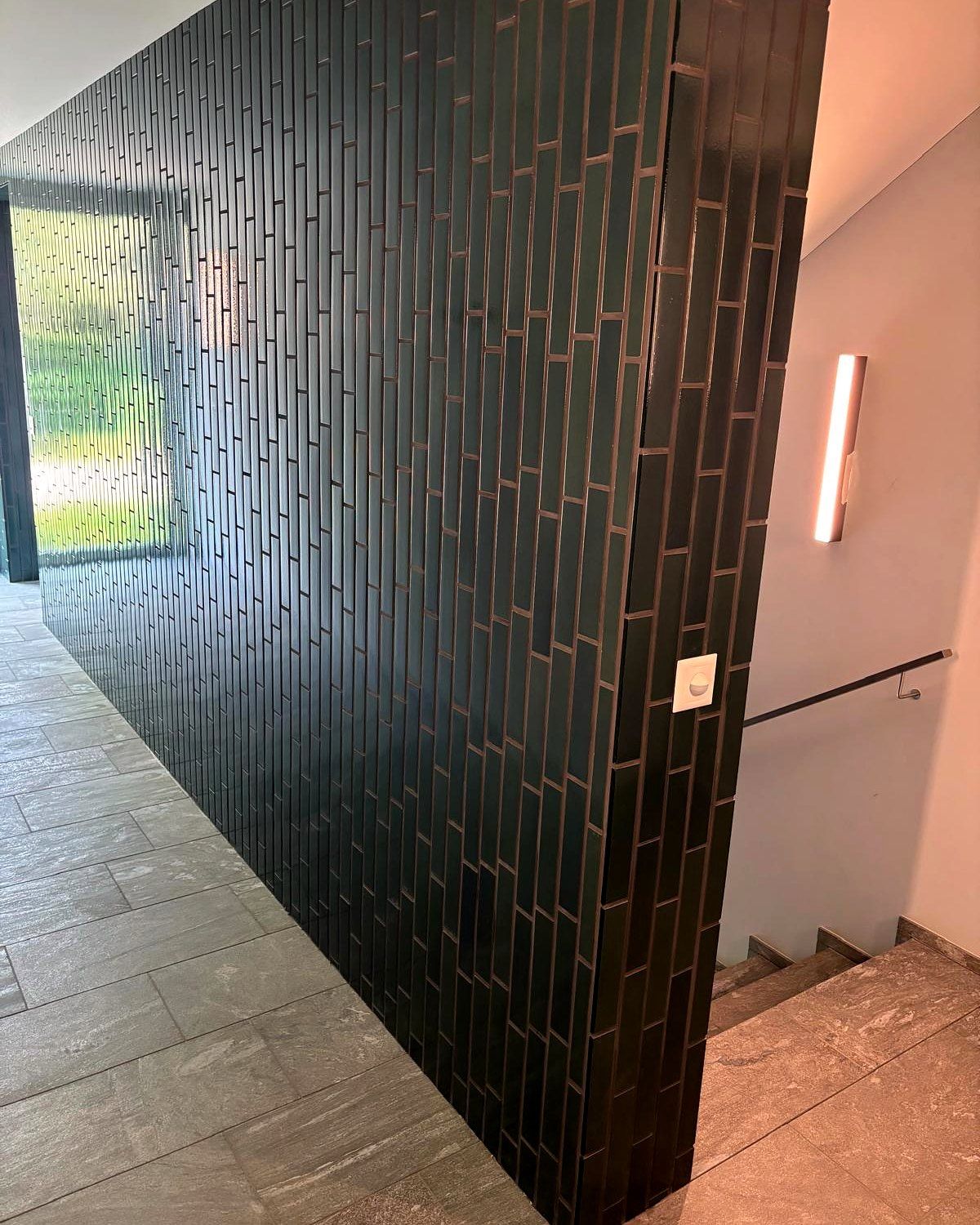 Treppenhaus mit dunkelgrün glasierten Wandplatten