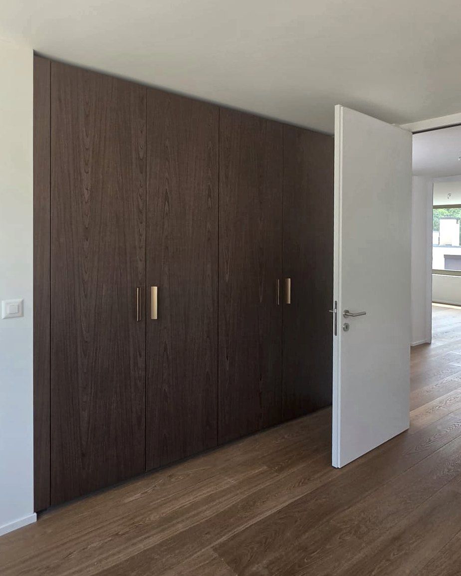 Raumhoher Einbauschrank in dunklem Holzfurnier