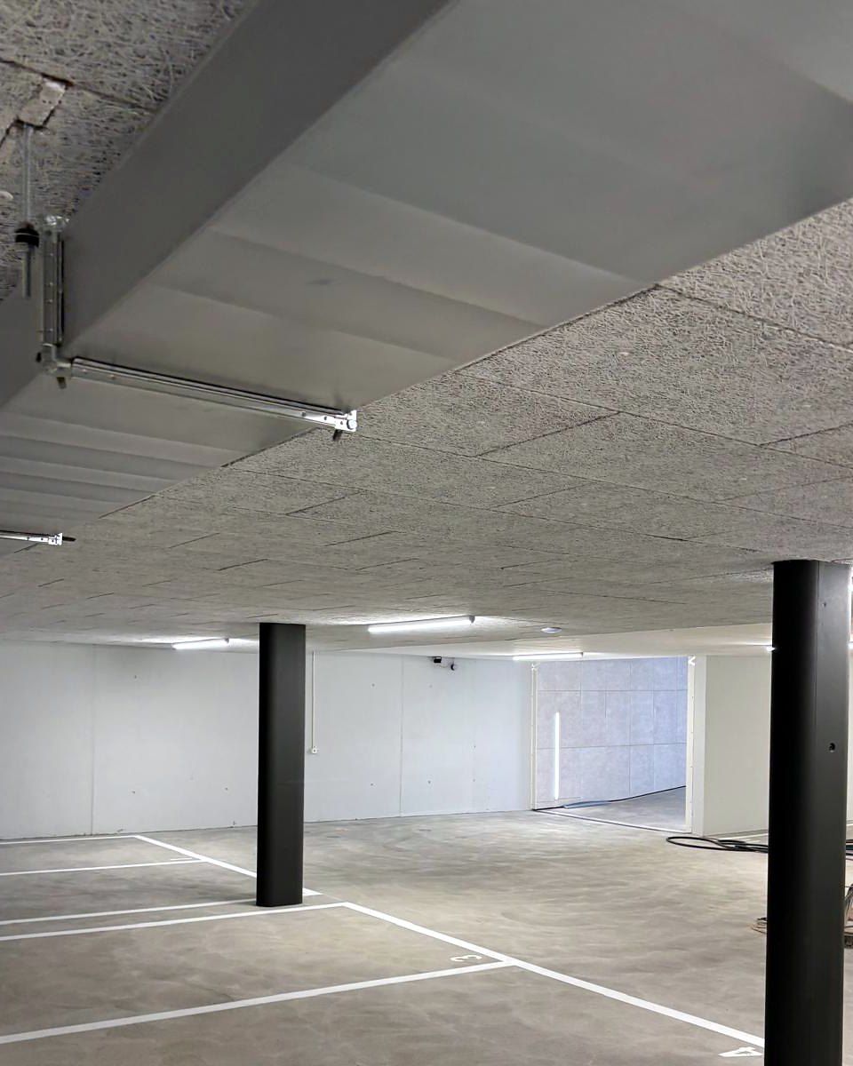 Tiefgarage mit schwarzen Stützen und markierten Parkfeldern